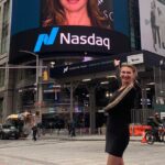 Dr. Shahnoz Rustamova standing next to her billboard