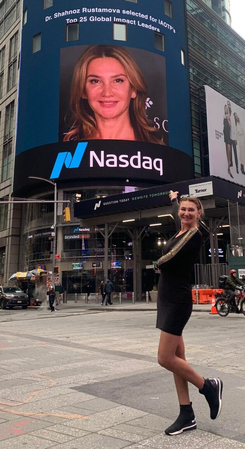 Dr. Shahnoz Rustamova standing next to her billboard