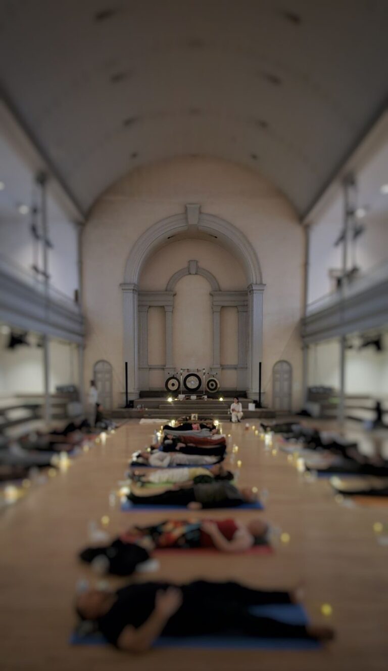 People laying down in a church, practicing breathing techniques